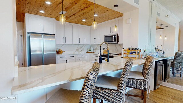 kitchen featuring stainless steel appliances, wooden ceiling, visible vents, and a peninsula