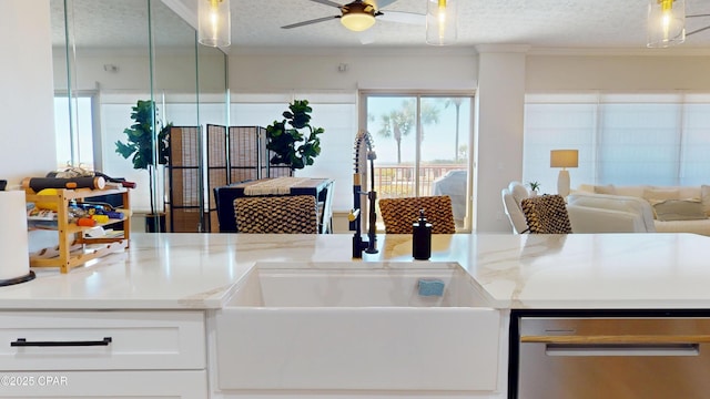 kitchen featuring open floor plan, a textured ceiling, a sink, and crown molding