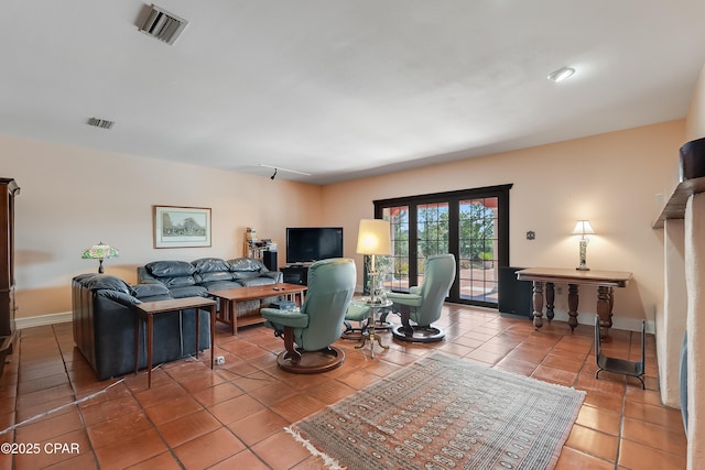 tiled living room featuring visible vents and baseboards