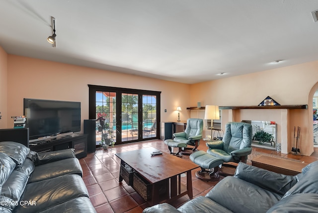 living room with arched walkways, visible vents, french doors, tile patterned floors, and rail lighting