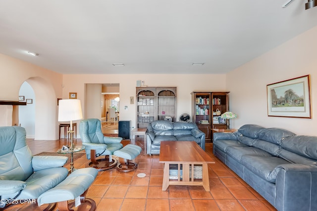 living area featuring light tile patterned floors and arched walkways