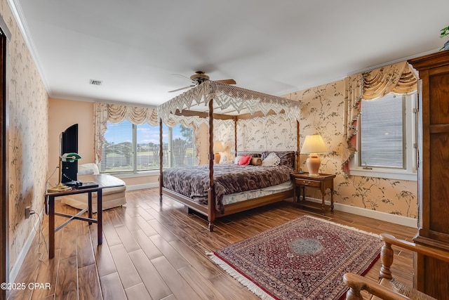 bedroom with wallpapered walls, baseboards, visible vents, and wood finished floors