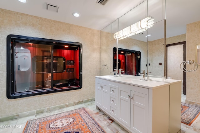 full bath featuring double vanity, visible vents, and a sink