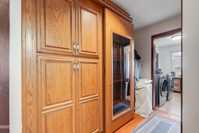 hallway with light tile patterned floors and independent washer and dryer