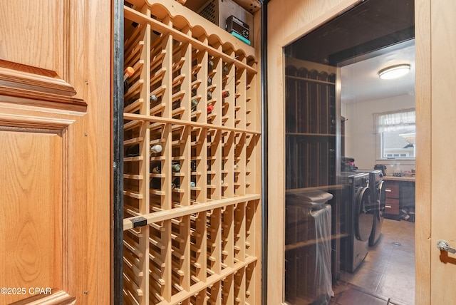 wine cellar featuring tile patterned floors and independent washer and dryer