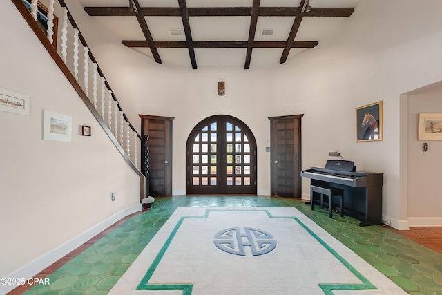 foyer entrance with french doors, coffered ceiling, baseboards, and stairs