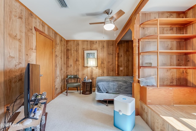 carpeted bedroom with wood walls and visible vents