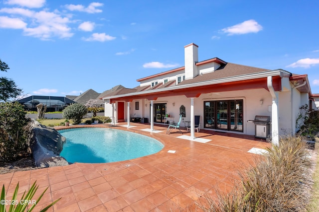 outdoor pool with a patio and a grill