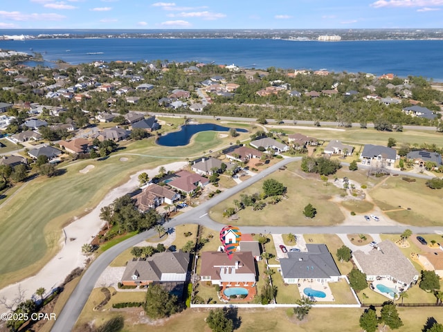 drone / aerial view with a residential view, a water view, and golf course view