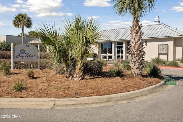 view of front of home featuring a standing seam roof, metal roof, and stucco siding