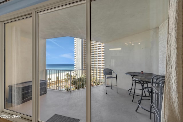 balcony with a water view and a beach view