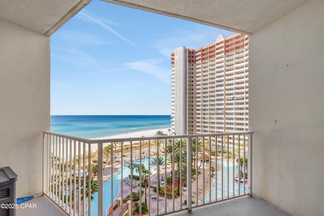 balcony with a water view and a view of the beach