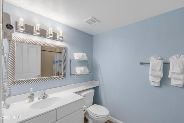 full bathroom with toilet, vanity, and visible vents