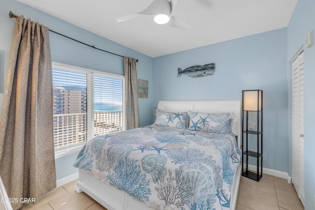 bedroom with a ceiling fan, baseboards, and light tile patterned floors