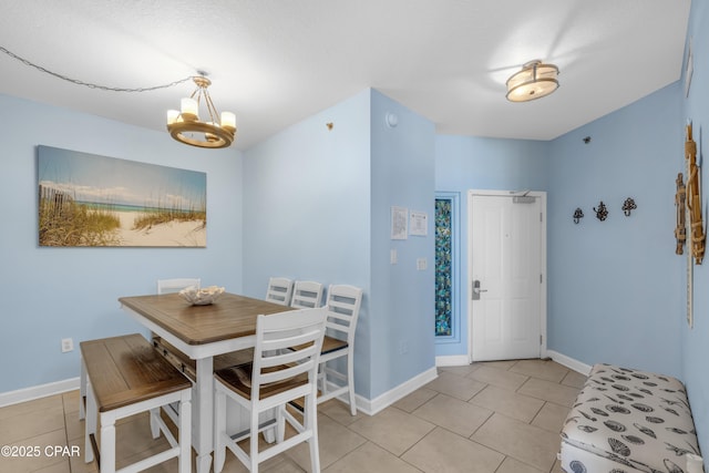 dining room with light tile patterned floors, baseboards, and an inviting chandelier