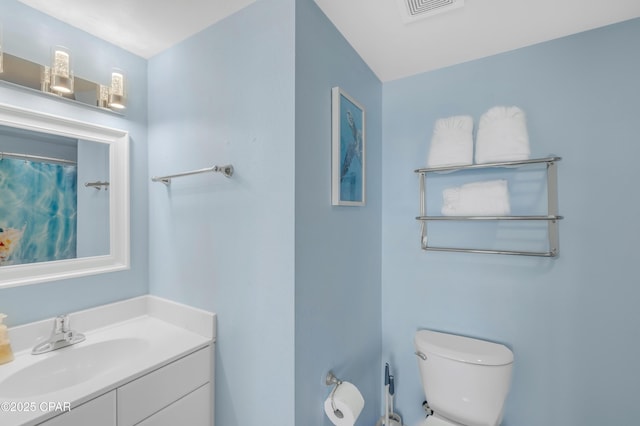 full bath with toilet, vanity, and visible vents