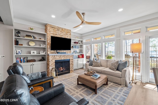 living area with a fireplace, wood finished floors, ceiling fan, and recessed lighting