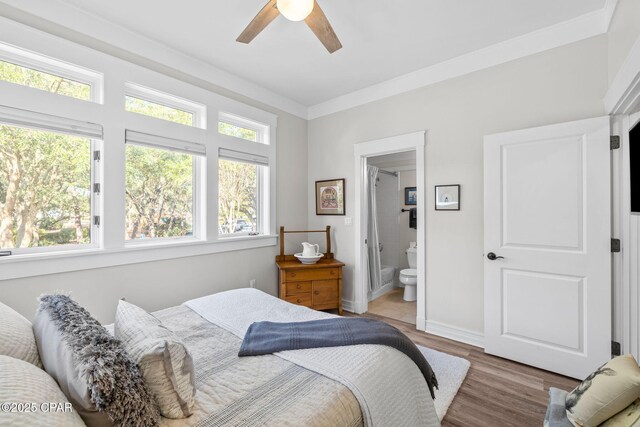 bedroom with light wood-style floors, ensuite bath, a ceiling fan, and baseboards