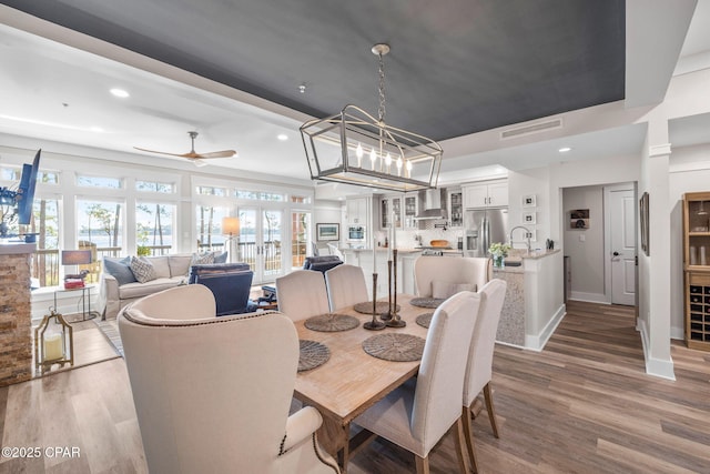 dining space with ceiling fan, wood finished floors, visible vents, and recessed lighting
