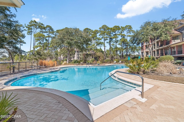 community pool featuring fence and a patio area