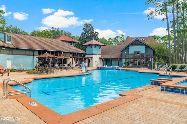 community pool featuring a hot tub and a patio area