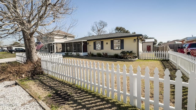 view of front of property featuring a sunroom and a fenced front yard