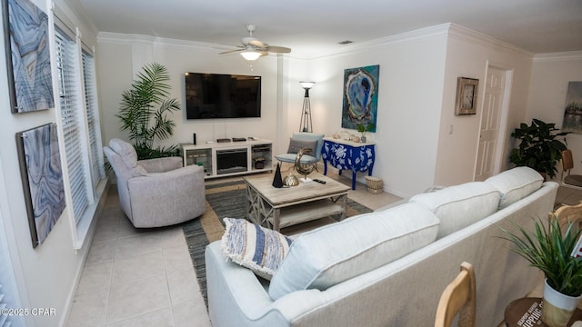 living area with light tile patterned floors, visible vents, a ceiling fan, baseboards, and ornamental molding