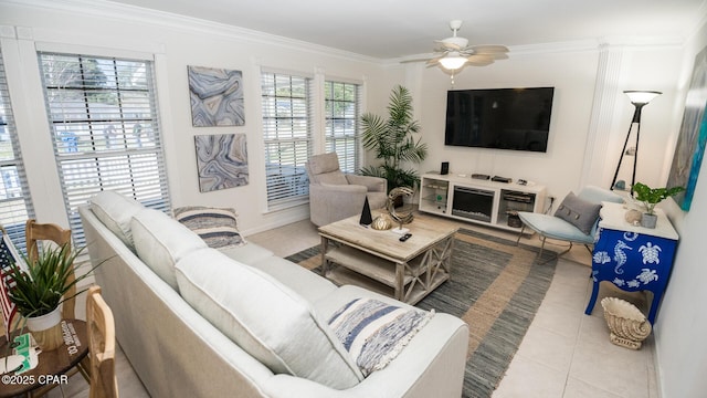 living room with a ceiling fan, a wealth of natural light, crown molding, and tile patterned floors