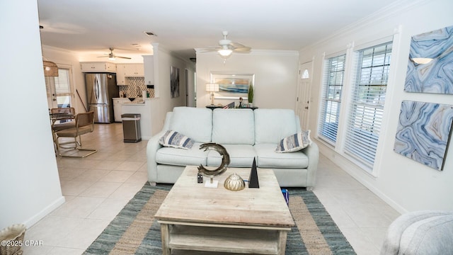 living room with light tile patterned floors, baseboards, ornamental molding, and ceiling fan