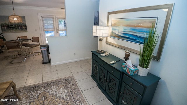 interior space with ornamental molding, light tile patterned flooring, and baseboards