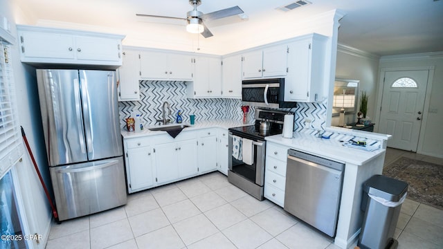 kitchen with crown molding, light countertops, visible vents, backsplash, and appliances with stainless steel finishes