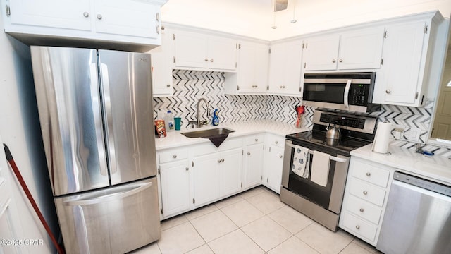 kitchen with stainless steel appliances, light countertops, and white cabinetry