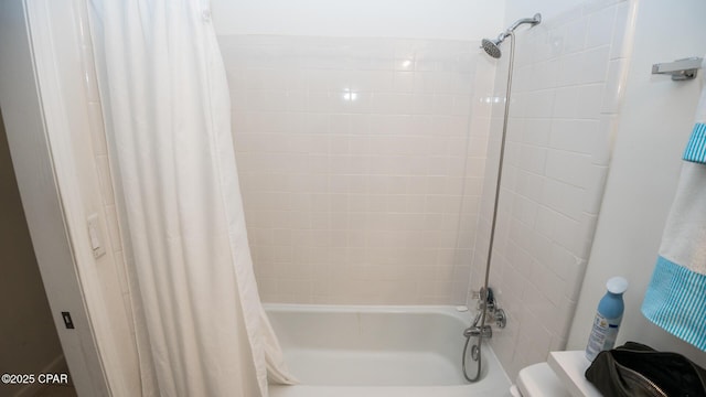 bathroom featuring shower / bathtub combination with curtain and toilet