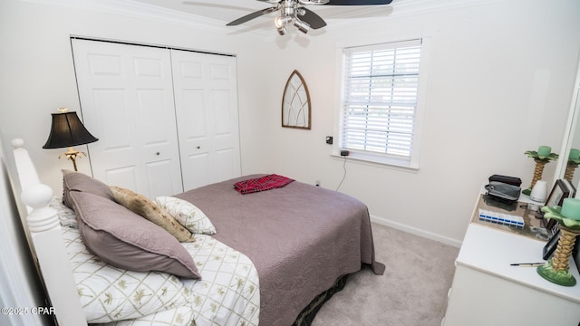 bedroom featuring baseboards, a ceiling fan, crown molding, carpet floors, and a closet