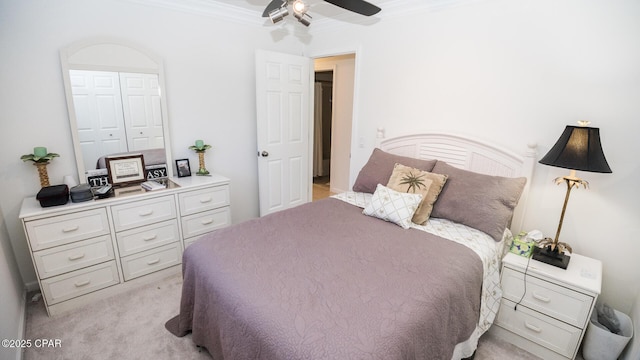 bedroom with ceiling fan, ornamental molding, and light colored carpet