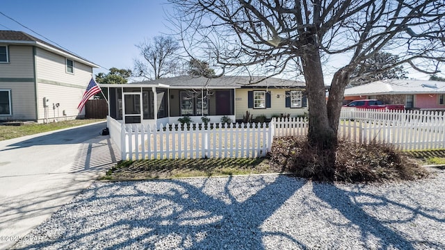 view of front of property with a sunroom and a fenced front yard