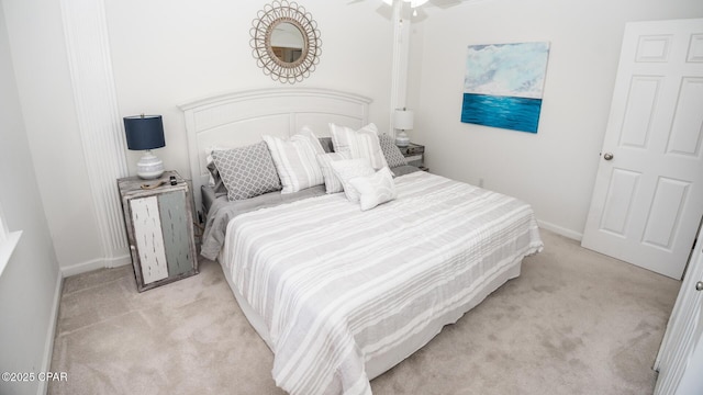 bedroom featuring light carpet and baseboards