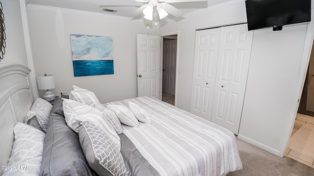 bedroom with a closet, visible vents, crown molding, and light colored carpet