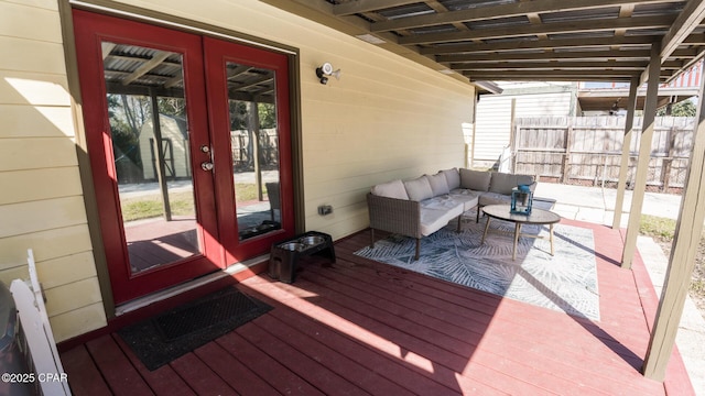 wooden terrace featuring french doors, fence, and an outdoor living space