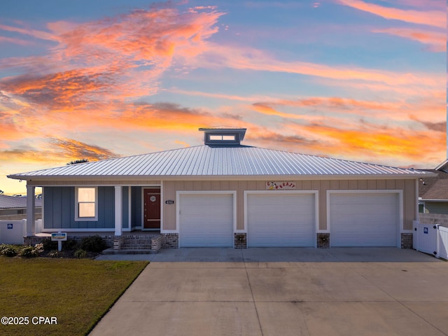 view of front of home with metal roof, driveway, board and batten siding, and fence