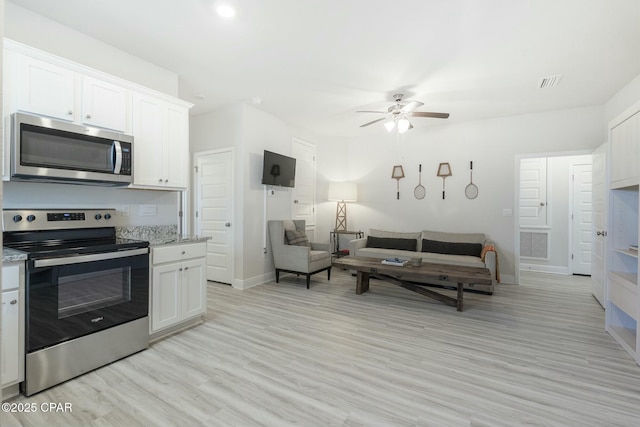 358 Sea Grove Way, Port St Joe, FL 32456 - kitchen with appliances with stainless steel finishes, ceiling fan, light wood finished floors, and white cabinetry