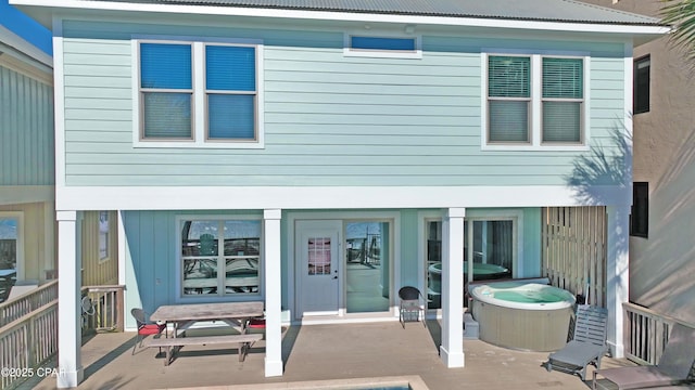 rear view of property with a jacuzzi