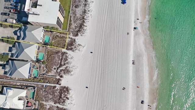 birds eye view of property featuring a beach view and a water view