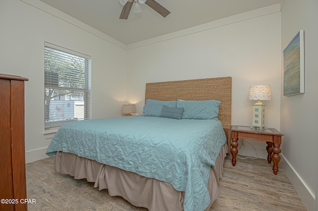 bedroom with baseboards, ceiling fan, and light wood finished floors