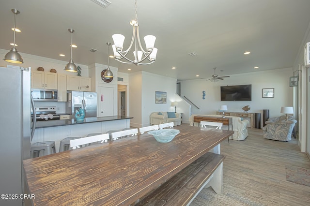 dining area with recessed lighting, visible vents, ornamental molding, light wood-style floors, and ceiling fan with notable chandelier