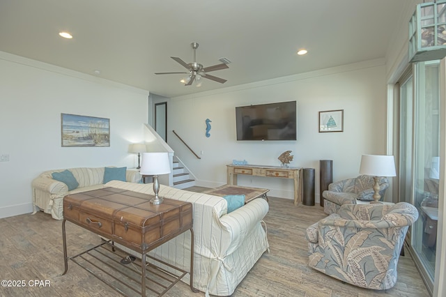 living area featuring ornamental molding, stairs, and wood finished floors