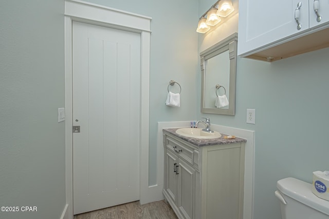 bathroom with vanity, toilet, and wood finished floors