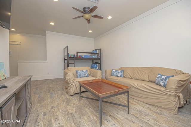 living area featuring ceiling fan, recessed lighting, wood finished floors, baseboards, and ornamental molding