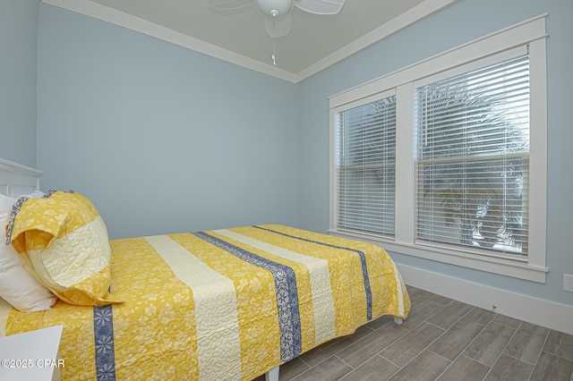 bedroom with wood tiled floor, multiple windows, ornamental molding, and ceiling fan