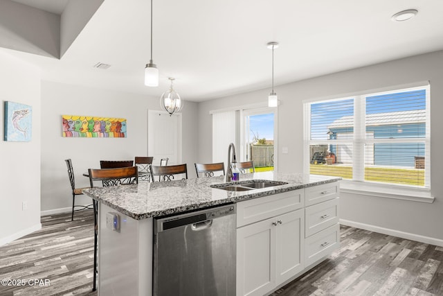 kitchen featuring stainless steel dishwasher, an island with sink, a sink, and light wood-style flooring